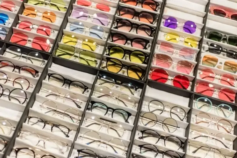 Collection de lunettes de différentes couleurs et formes exposées en magasin
