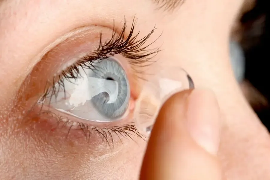 Femme préparant une lentille de contact progressive avant de la poser sur son œil pour une vision nette à toutes distances