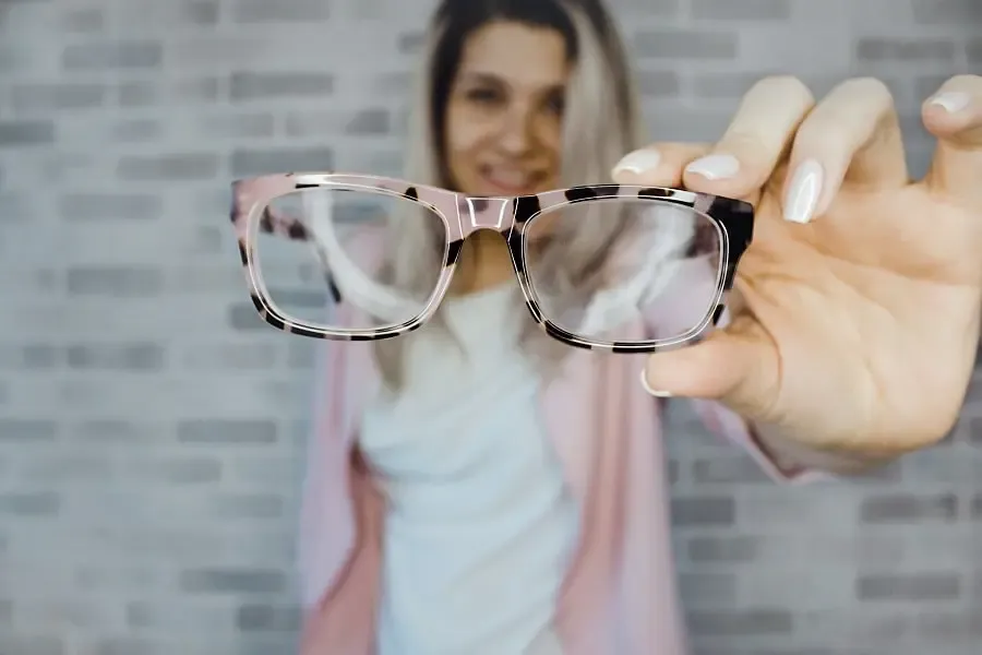 Femme heureuse ayant retrouvé ses lunettes de vue, illustrant le soulagement et le confort visuel