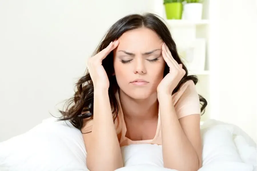 Femme souffrant d’une migraine ophtalmique, illustrant la douleur et l’inconfort visuel