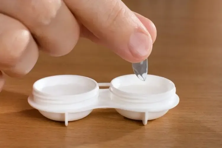 Personne rangeant ses lentilles de contact de nuit dans leur blister pour les protéger