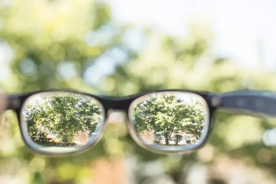 Comparaison de la vision d’une personne astigmate : arrière-plan flou sans lunettes et premier plan net avec lunettes