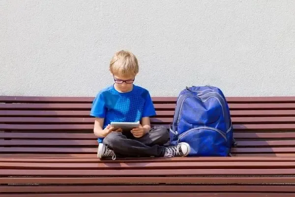 Enfant portant des lunettes anti-lumière bleue en utilisant une tablette