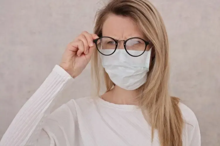 Femme avec de la buée sur ses lunettes