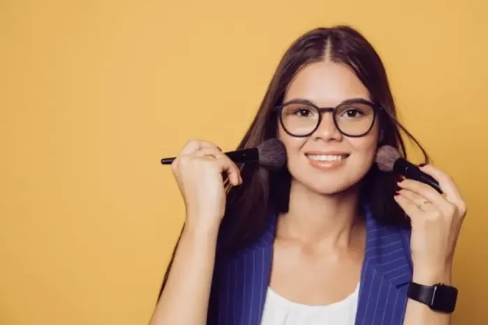 Jeune femme portant des lunettes de vue en train de se maquiller, illustration du maquillage avec lunettes