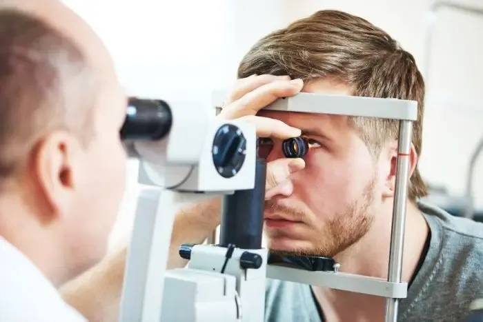 Homme réalisant un test de vue pour vérifier sa myopie et évaluer sa correction visuelle