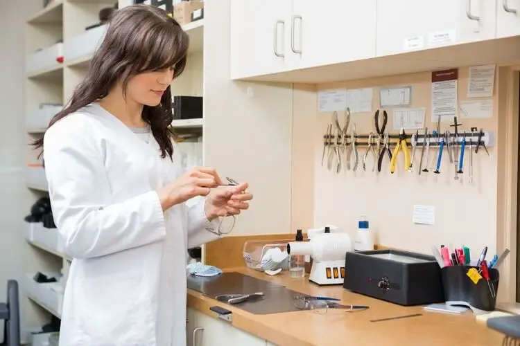 Opticien ajustant des lunettes de vue dans son atelier pour un confort et une vision optimale