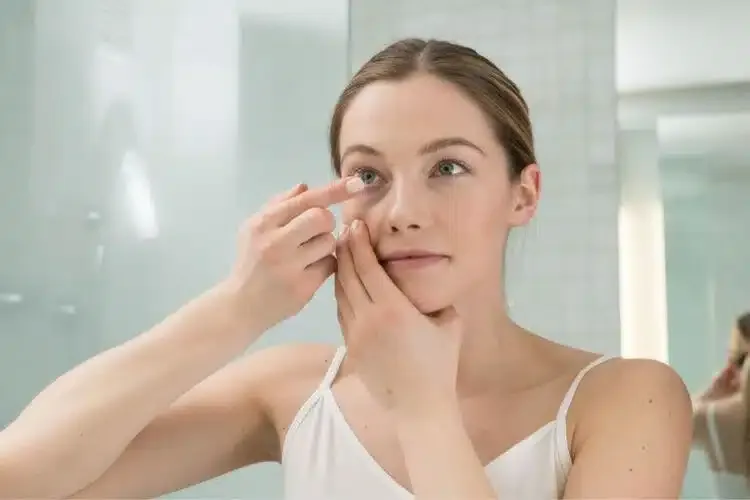 Femme mettant une lentille de contact sur son œil pour corriger sa vision