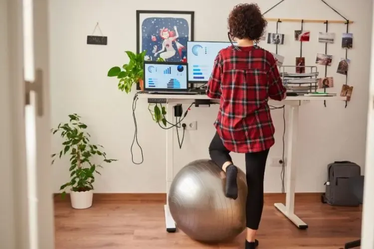 Femme travaillant devant un écran dans un environnement de travail ergonomique et adapté pour réduire la fatigue oculaire