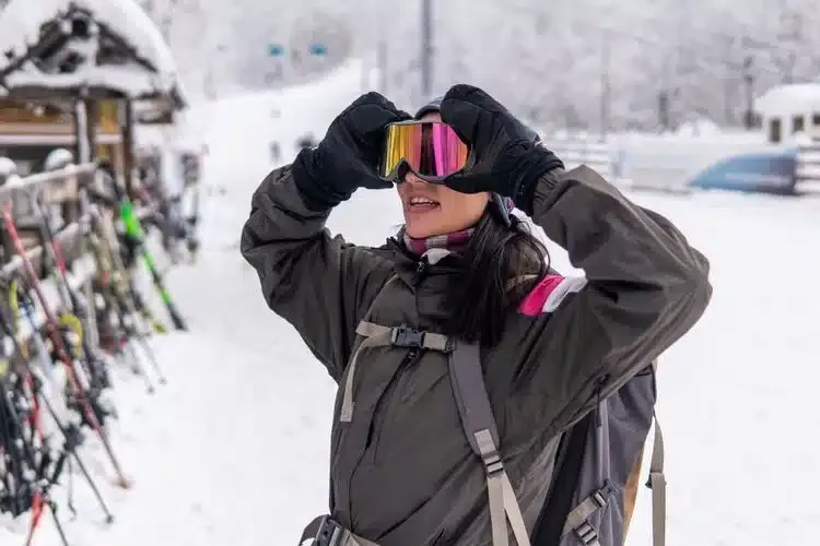 Femme pratiquant le ski portant un masque de ski avec correction optique intégrée pour une vision nette sur les pistes