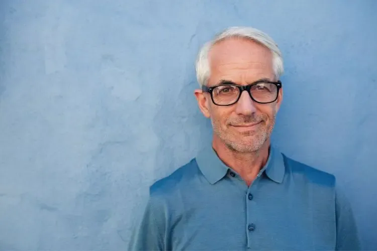 Homme hypermétrope portant des lunettes pour corriger sa vision de près et améliorer son confort visuel