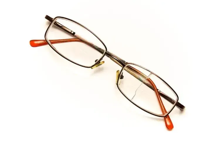 Paire de lunettes avec des verres correcteurs très abîmés et rayés, nécessitant un remplacement