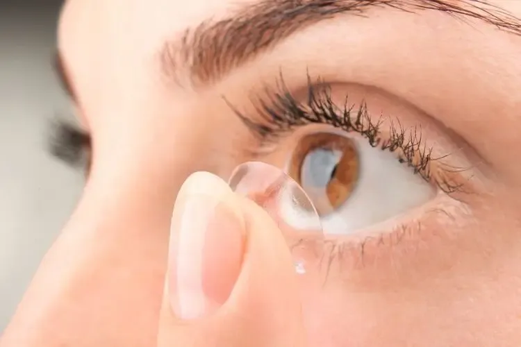Femme mettant une lentille de contact d’orthokératologie pour corriger la myopie pendant la nuit
