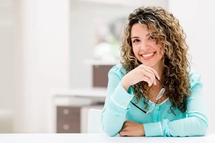 Femme souriante profitant d’une vision claire pendant la journée grâce aux lentilles d’orthokératologie portées la nuit